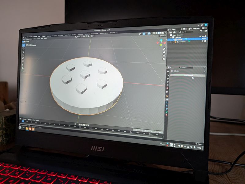 Auf einem Bildschirm sieht man, wie in Blender das "Kunchumer Pfeffer" Symbol in das Modell eines Warensteins "gestanzt" wird. 